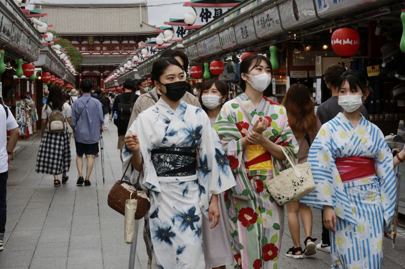 日本民眾13日戴口罩經過東京淺草仲見世商店街。美聯社