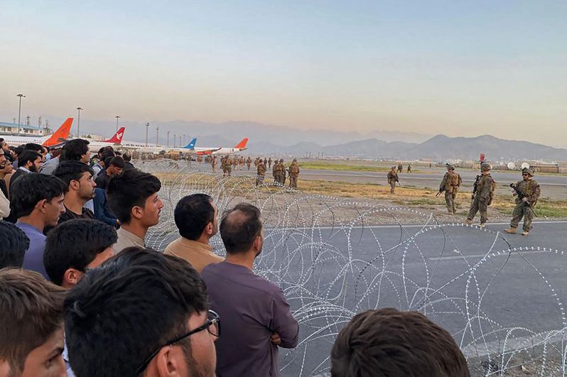 负责喀布尔机场维安的美军十六日隔着铁丝网，和想要搭机逃离的阿富汗民众对峙。（法新社）(photo:UDN)
