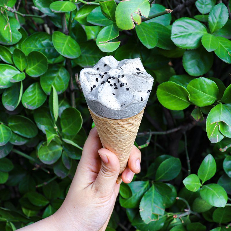 「韓國熊津黑芝麻年糕冰淇淋」撒上真實芝麻粒，濃郁芝麻香氣搭配冰淇淋甜筒，口感香濃綿密。圖／7-ELEVEN提供