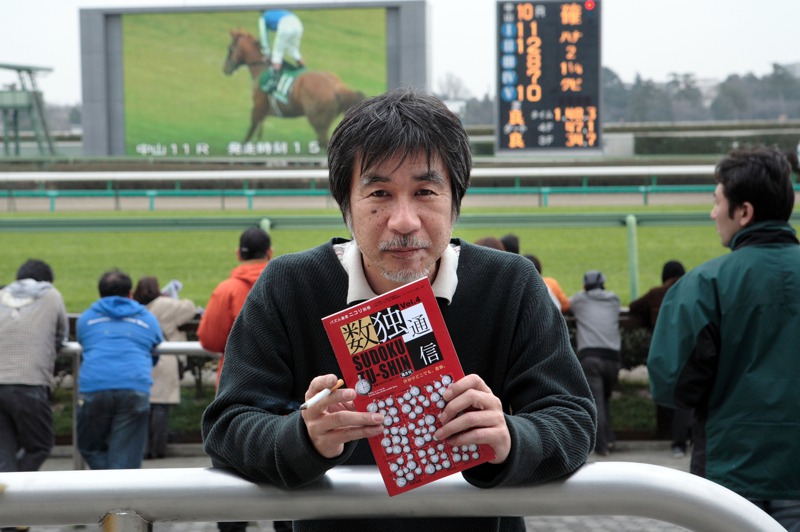 益智遊戲「數獨」的取名者、日本尼柯利公司創辦人鍜治真，2007年時現身日本船橋市的賽馬場，當時他手上拿著一本數獨雜誌。圖／紐約時報