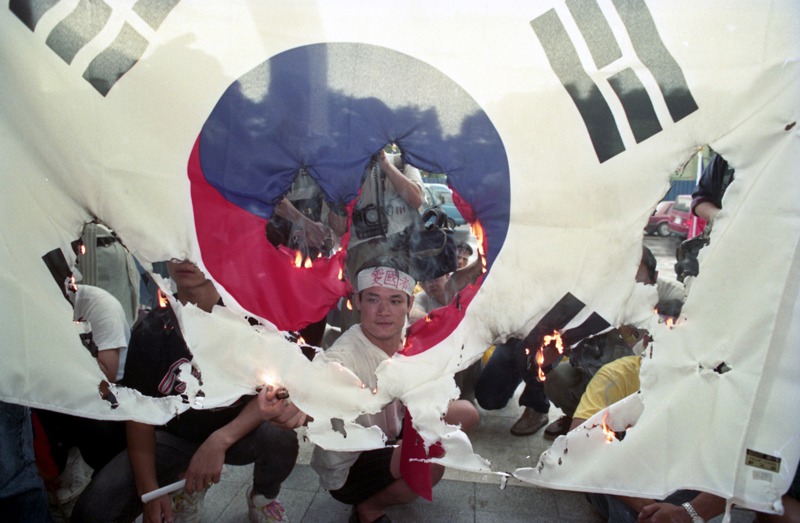 1992年8月20日，中韓斷交消息傳出後，20多名義憤填膺的市民，在大雨中前往韓國大使館門口靜坐抗議，焚燒韓國國旗。圖／聯合報系資料照片