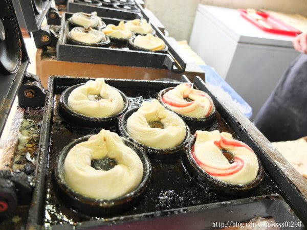 放入甜甜圈專用的烤爐裡，一共四台機器在烤，每一台可以烤五個甜甜圈