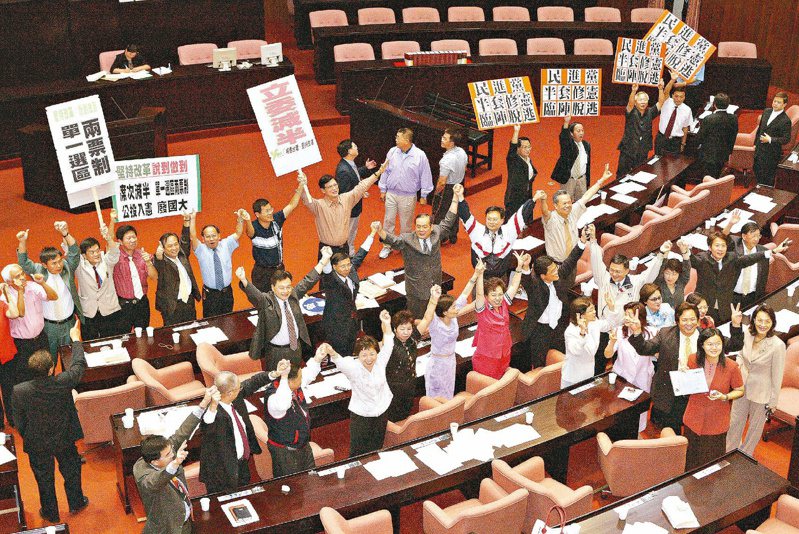 立法院8月23日三讀通過修憲案後，各黨立委拿出各式各樣的標語，高舉雙手，一起歡呼慶祝。圖／聯合報系資料照片