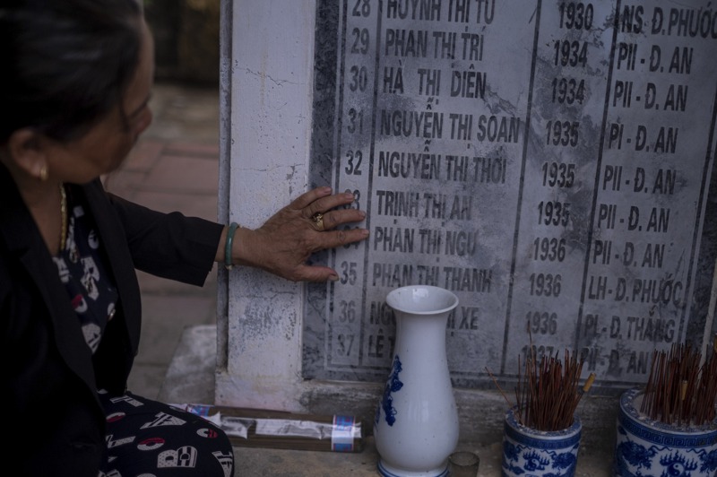 越南人阮氏清是越戰時期豐一村及豐二村屠殺事件倖存者，圖為她在廣南省一處紀念碑指著罹難人姓名。圖／取自紐約時報