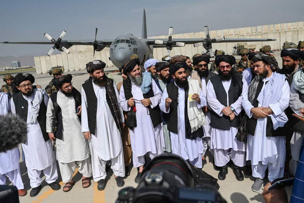 快樂的塔利班幹部更是號召眾將士排排站好，以被俘虜的阿富汗C-130運輸機為背景「...