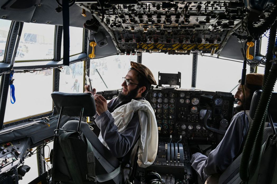 圖為美國撤軍後，跑到阿富汗空軍駕駛艙內的塔利班戰士。 圖／法新社