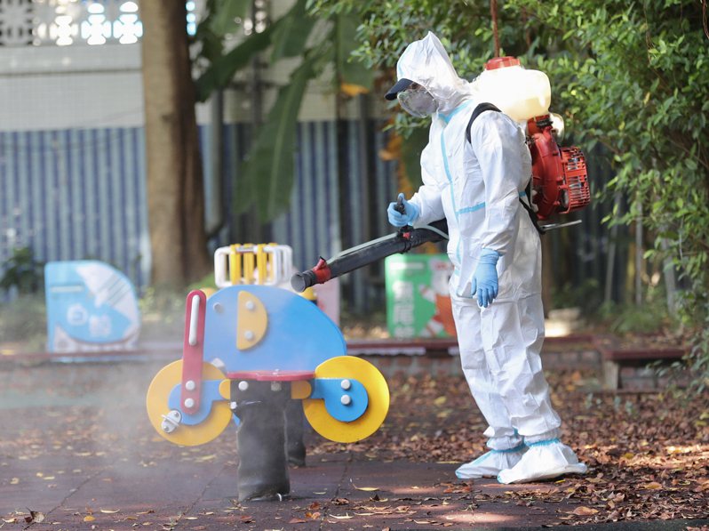 新北市某幼兒園爆發COVID-19群聚感染，消毒人員針對遊樂器具等進行大清消。中央社