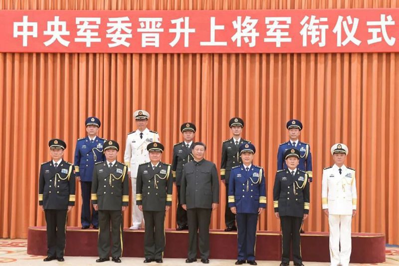 中共中央軍委主席習近平（中）等軍方高層，與新晉升的上將合影。 圖／截自央視新聞