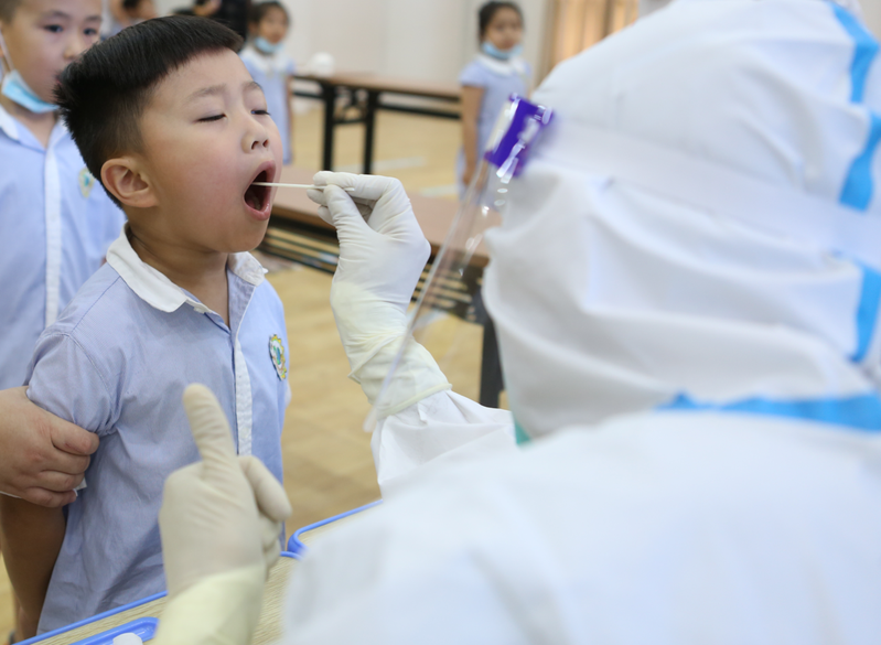 防堵校園疫情，福建對各級學校師生展開核酸普篩。圖為醫護人員為晉江市第二實驗幼兒園學童進行核酸檢測採樣。新華社