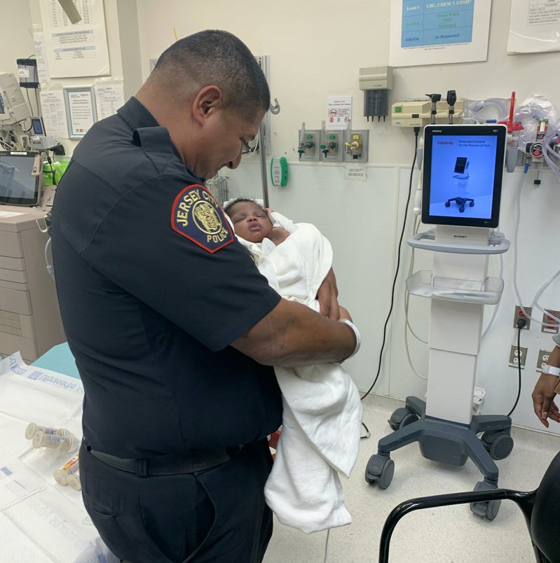 警察在醫院抱著他徒手接住的嬰兒。圖／取自twitter