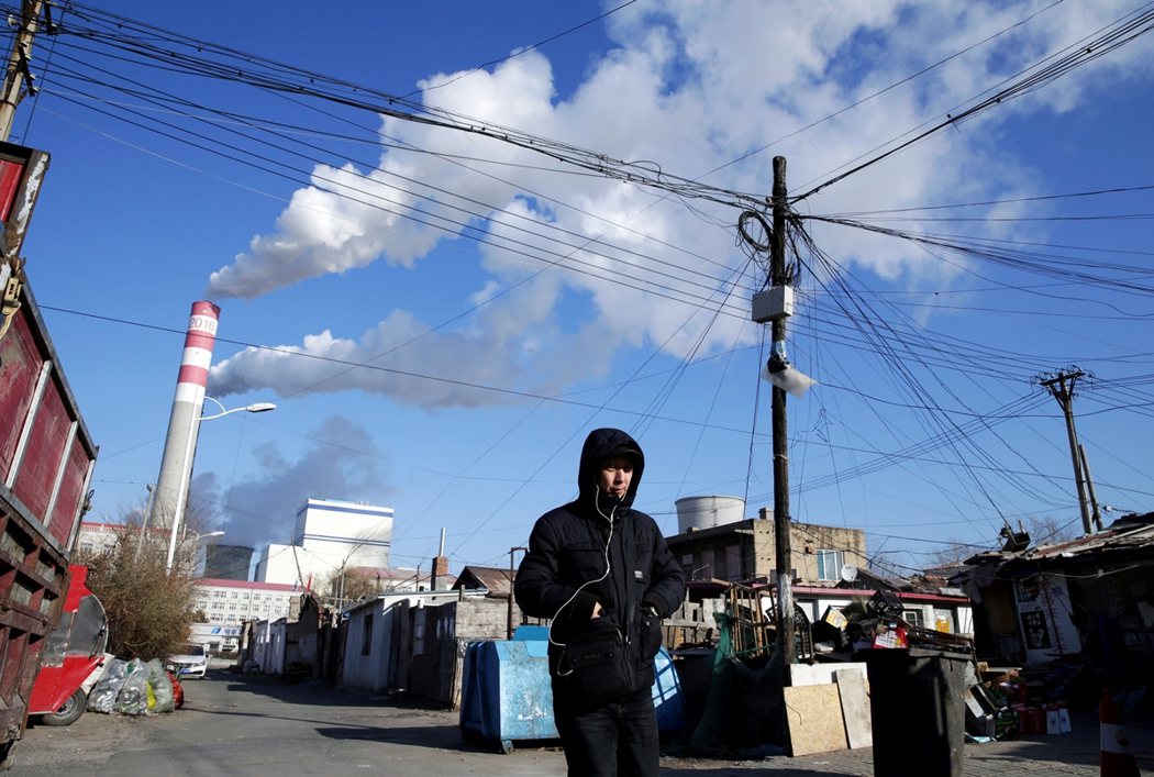 一名男子走過黑龍江的燃煤發電廠。 圖／路透社