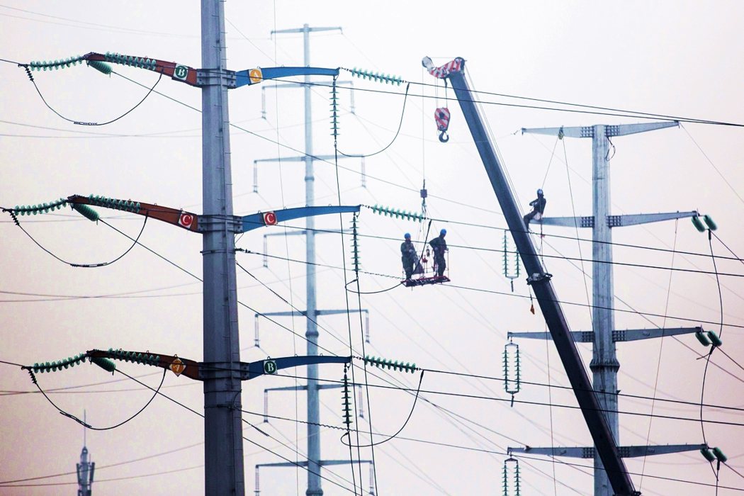 2016年，安徽省淮北市，員工在升級當地電網時在塔架上工作。 圖／路透社