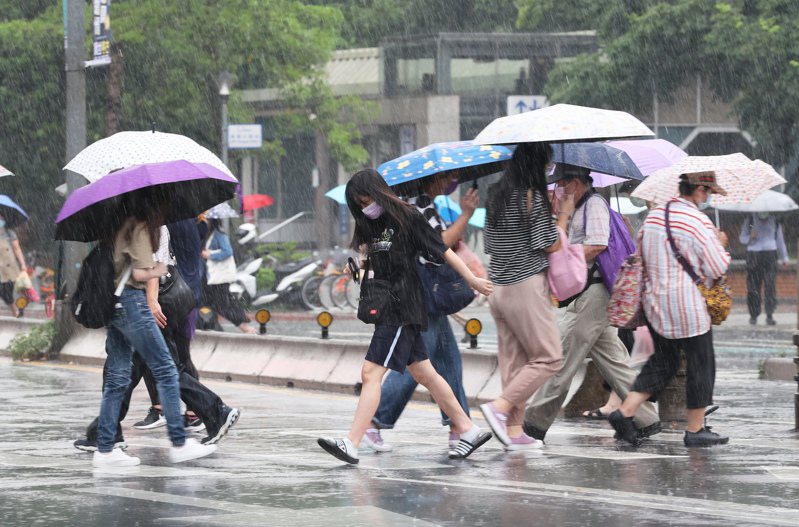 近日午後對流旺盛，昨天台北市下起午後雷陣雨，沒帶雨具的民眾遇上突如其來的雨勢只好快步過馬路。圖與文／潘俊宏 潘俊宏
