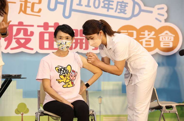 藝人譚艾珍（左）擔任衛福部疾管署的防疫大使，在記者會中挽袖施打流感疫苗。衛福部疾...