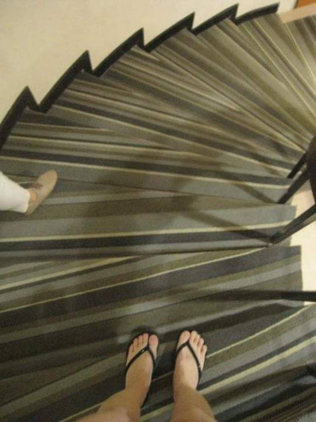一名網友在臉書貼出一張樓梯照，灰色橫條紋的地毯花色讓人眼花瞭亂。 圖／「奇葩裝潢...