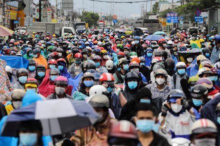 騎著摩托車的越南民眾上周五蜂擁離開胡志明市。 路透