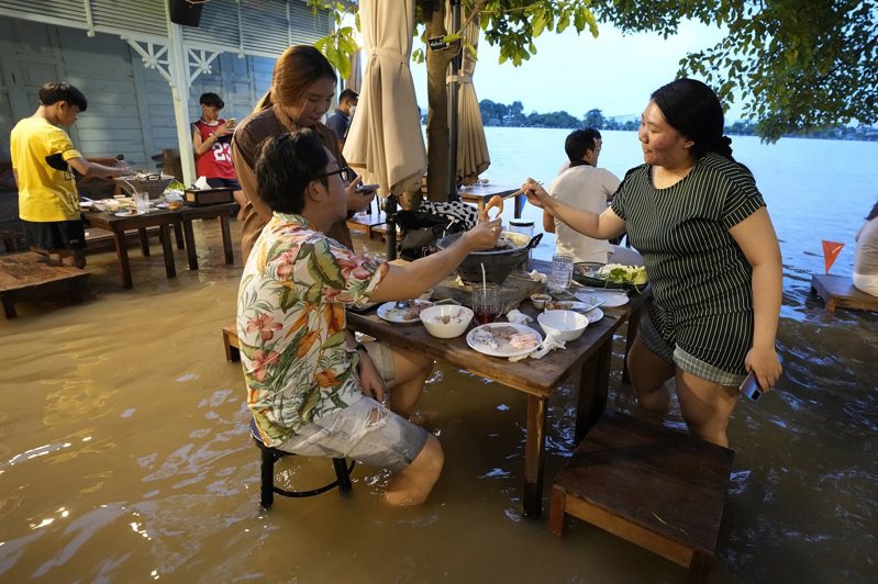 「Chaopraya Antique Café」靠着媒体宣传推波助澜，现在不仅没有门可罗雀，反而和以前一样高朋满座和大受欢迎。毫无顾忌的食客们挤满用餐区，开心地狼吞虎嚥，彷彿在大水中吃饭是再正常不过的事情。 美联社(photo:UDN)