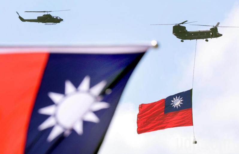 雙十國慶大典 中，CH-47運輸直升機吊掛典禮史上最巨幅國旗總長達18公尺、寬12公尺，在阿帕契與眼鏡蛇攻擊直升機伴隨下，通過總統府上空。記者黃義書／攝影