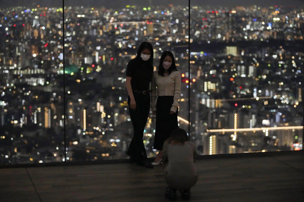 東京疫情持續降溫，圖為民眾9日在澀谷Shibuya Sky觀景台合照。美聯社