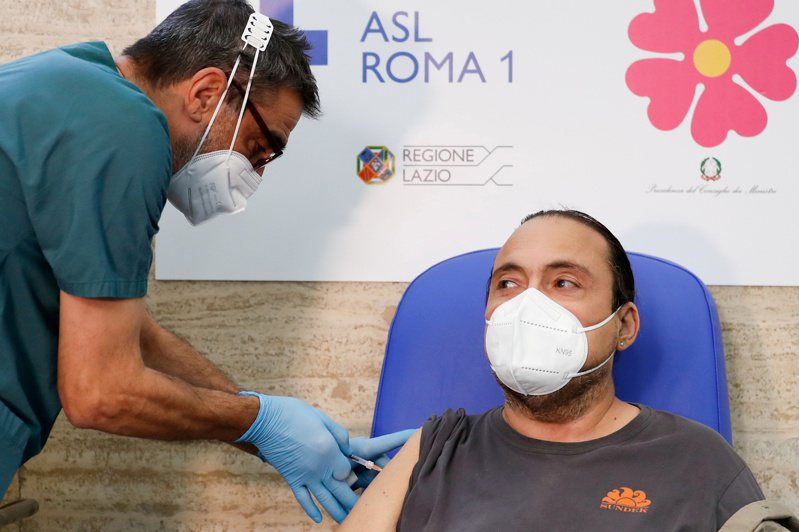 一名醫護人員在義大利羅馬為民眾注射新冠疫苗第三針。（路透）