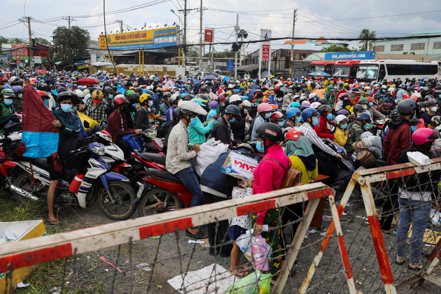 越南準備返鄉的工人在檢查站等待。路透