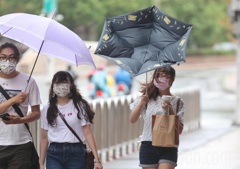 受圓規颱風外圍環流影響，台北市上午不時有陣雨，外出民眾雨傘遭大風吹翻。記者陳正興／攝影