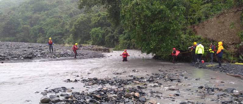 13名遊客受困在宜蘭大同鄉石門溪，搜救人員正涉溪要進去救人。 圖／消防局提供