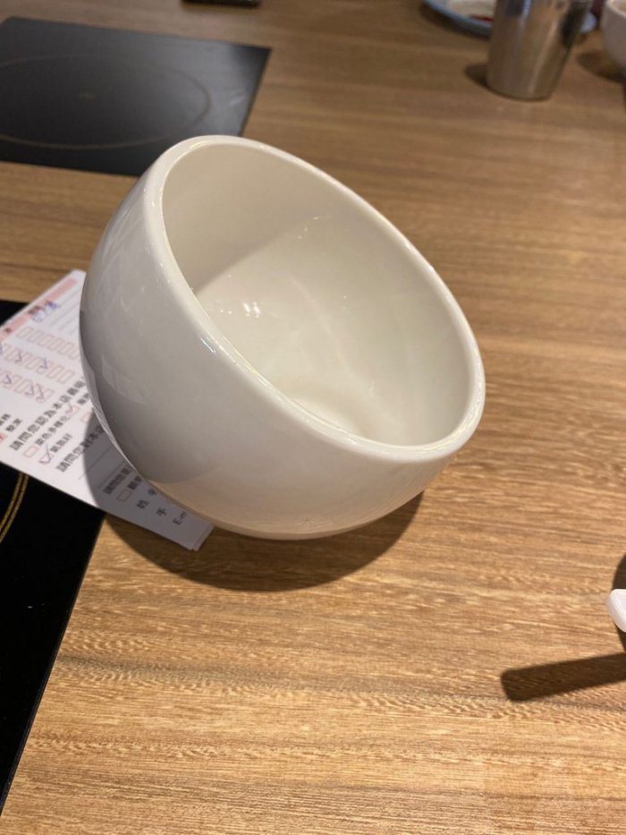 一名網友到火鍋店用餐，在桌上看到一個造型特殊的碗，讓他好奇有什麼用途。 圖／翻攝自《Dcard》