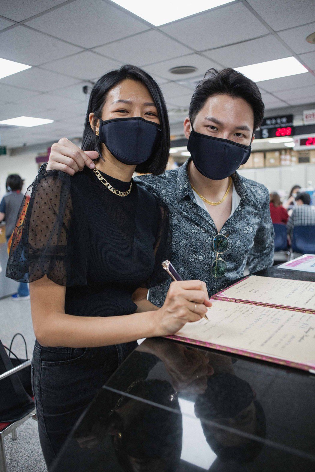 楊昇(右)和老婆若綺到戶政事務所辦理結婚登記時以口罩遮住半張臉。 圖／伊林娛樂提...