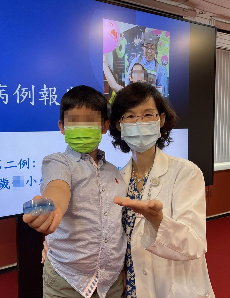 醫師陳亮如（右）說明，8歲男童（左）經配戴牙套式肌肉功能矯正器治療一年，牙齒排列...