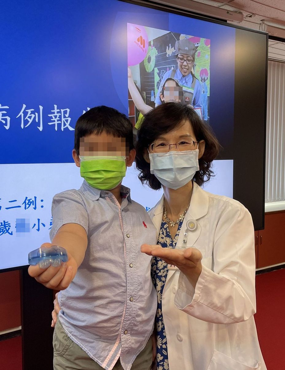 醫師陳亮如（右）說明，8歲男童（左）經配戴牙套式肌肉功能矯正器治療一年，牙齒排列變整齊，呼吸順暢，也長高、長壯。圖／台中榮總提供