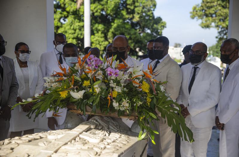 海地總理亨利（中）出席開國元勳戴沙林的紀念儀式，卻遭全副武裝的幫派開槍驅趕。美聯社