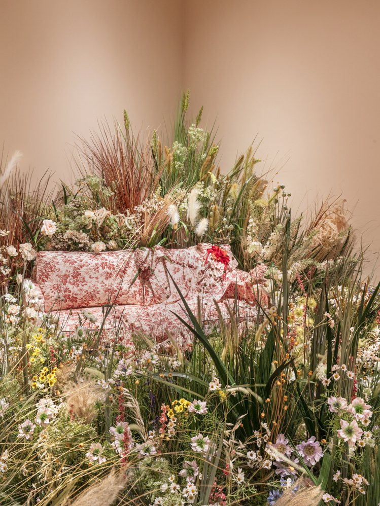 花悅仙境展間裡的粉色印花沙發重現廣告中出現的洋裝，周圍滿滿的花草搭配粉色牆面，像...