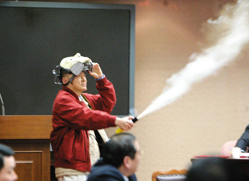 已故知名作家李敖，2006年10月24日擔任立委時，在立院程序委員會噴防暴噴霧表達不滿。圖／聯合報系資料照片