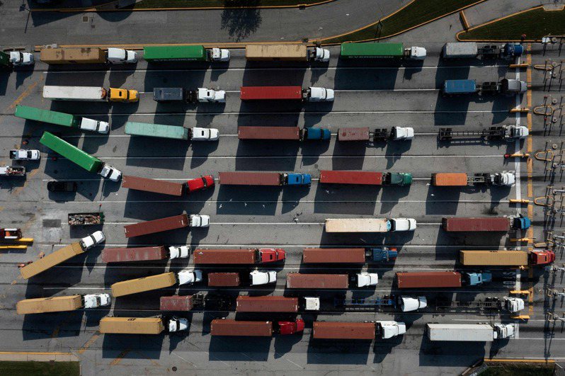 葉倫24日認為供應鏈瓶頸導致的通膨是暫時性的，圖為14日巴爾的摩港口內大排長龍的貨櫃卡車。法新社