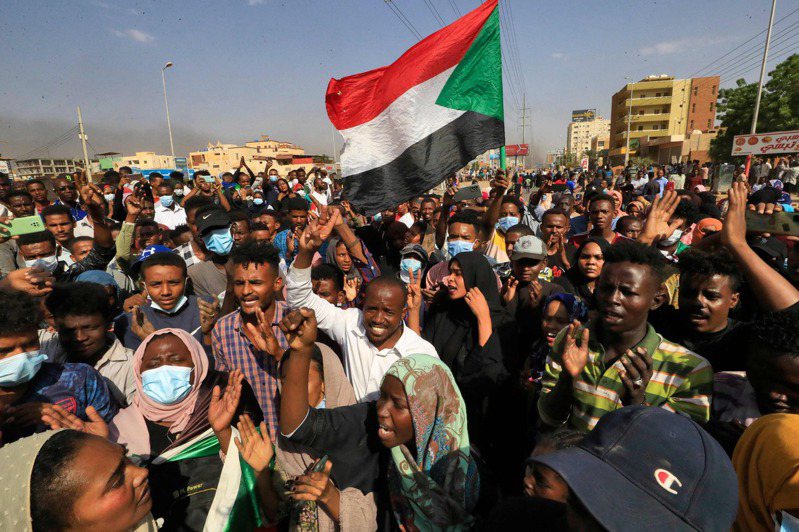 蘇丹民眾廿五日在首都喀土穆高舉國旗示威，抗議軍事政變。（法新社）