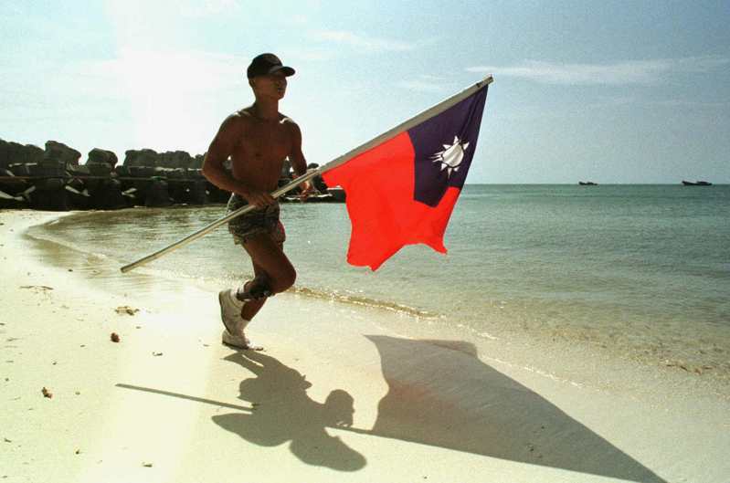 中华民国海军陆战队队员1999持国旗在东沙岛海边慢跑。（美联社）(photo:UDN)