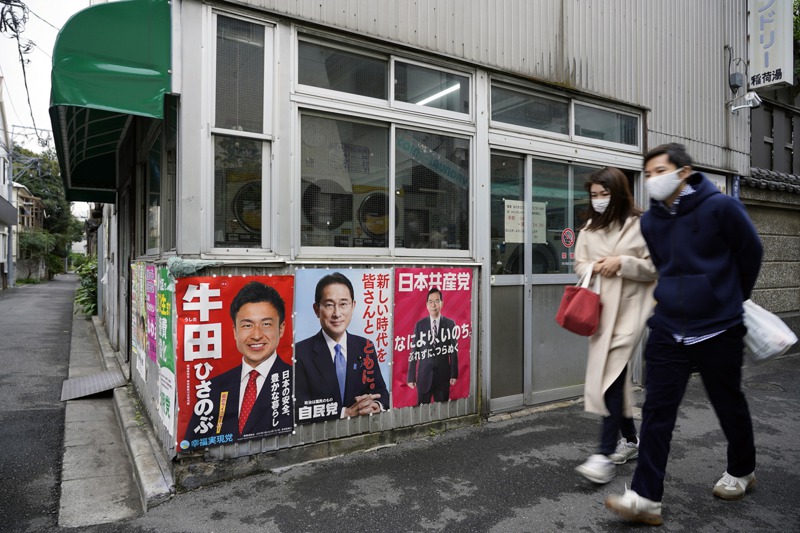 在東京一處巷口，日本共產黨領導人志位和夫的海報（右）和自民黨黨魁岸田文雄的海報（中）貼在一起。 歐新社