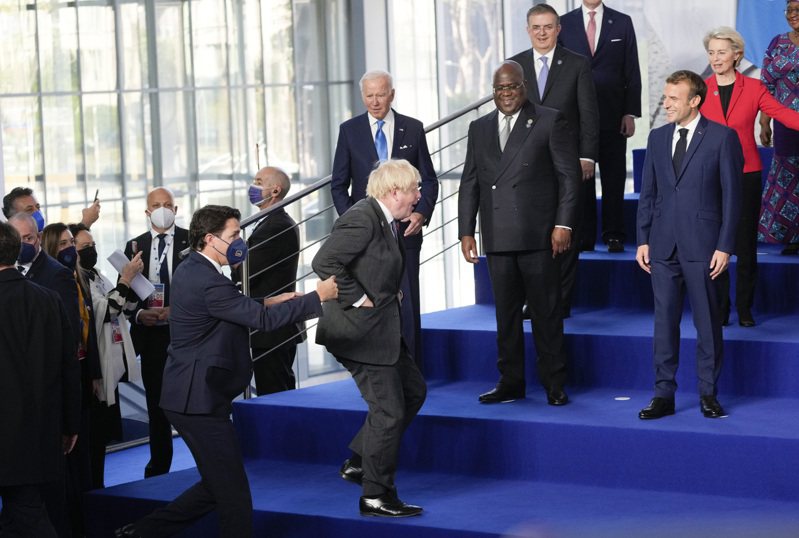 英國首相強生（中）30日與加拿大總理杜魯多（左）匆匆跑上台，其他領袖搞笑地發出斥責聲。（美聯社）