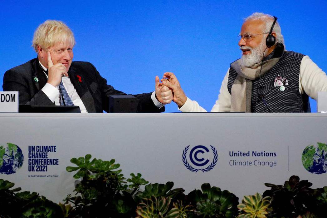 COP26東道主英國首相強生（左）二日與印度總理莫迪握手。（法新社）