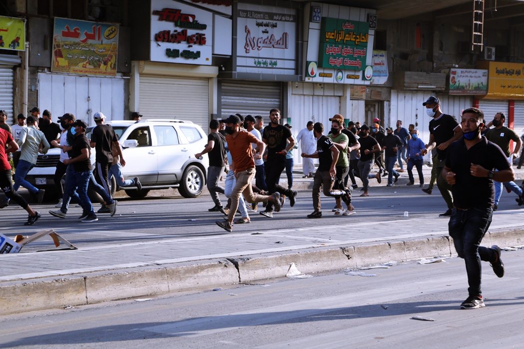 11月5日在巴格達的抗議活動，什葉派武裝團體支持者逃離政府安全部隊的鎮壓。 圖／...