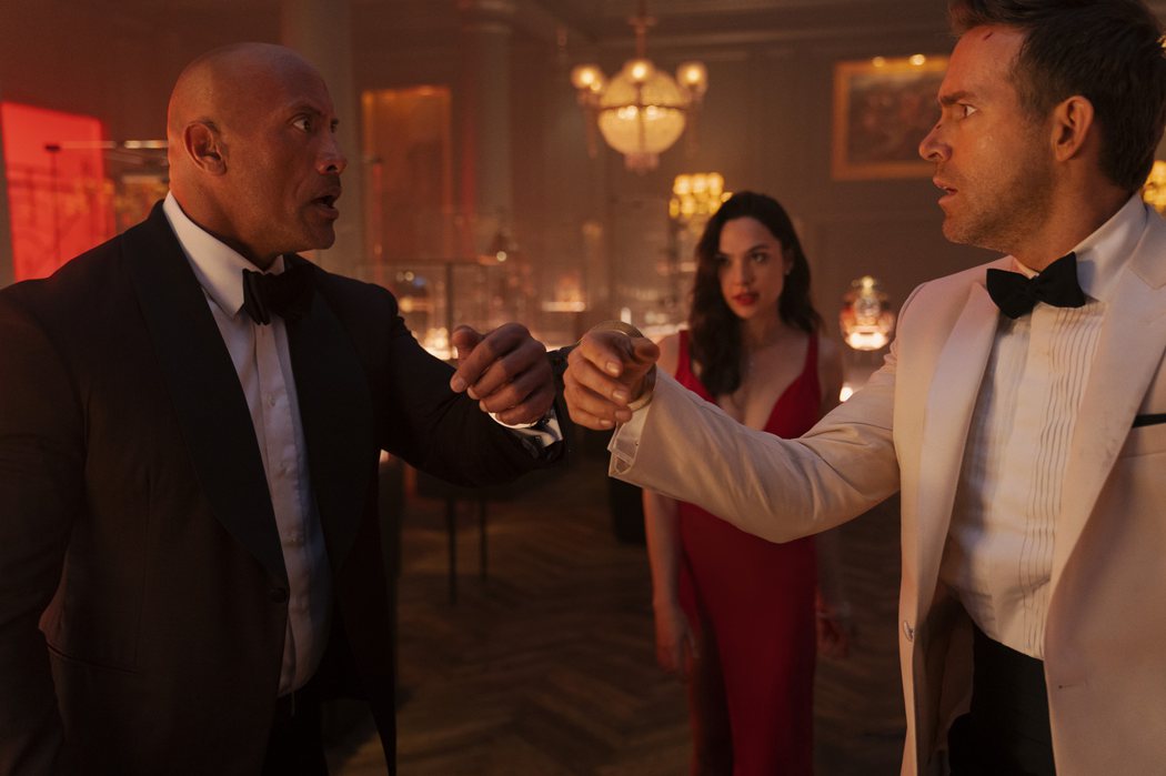 巨石強森(左)、蓋兒加朵以及萊恩雷諾斯在「紅色通緝令」挑戰眾多高難度動作戲。圖／Netflix提供