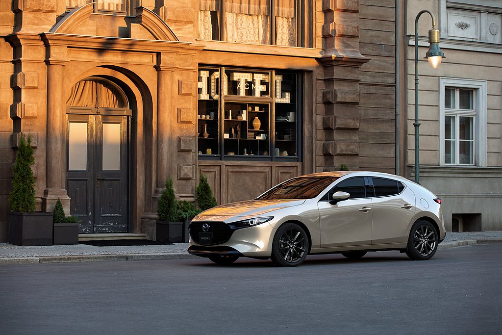 2022年式Mazda3導入全新車色「琉光金」，石英般的透亮光澤中閃耀鉑金迷人風采，細膩柔滑的光影流動使車身線條更顯獨特。 圖／Mazda提供