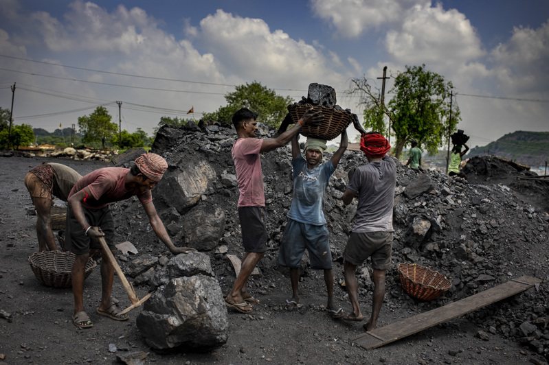 印度在氣候峰會最後一刻提出把煤電「逐步淘汰」改為「逐步減少」。圖為印度煤炭儲量最多的賈坎德邦工人把煤炭搬上卡車運出。（美聯社）