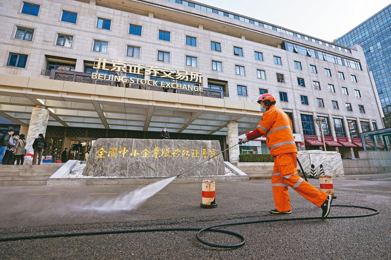 北京證券交易所十一月十五日開市。圖為開市前一天，清潔工人在交易所前清洗路面。（美聯社）