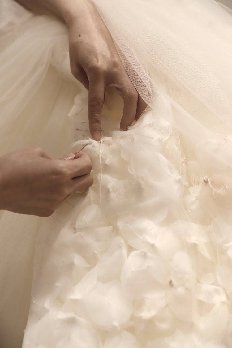 這二款禮服共花費1200小時製作，運用了大量的手工立體花朵營造出浪漫氛圍。圖／N...