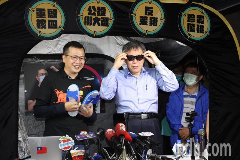 台北市長柯文哲（右）晚間帶著紅豆湯到凱道探班，和羅智強（左）相互調侃贈送藍白拖和墨鏡給對方。記者林澔一/攝影