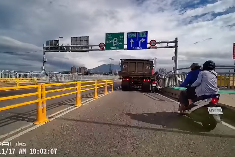 一名網友分享行經關渡大橋時，行車記錄器拍下的機車騎士與砂石車擦撞畫面。
圖擷自...