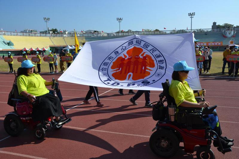 台南市身心障礙國民運動會昨天登場，坐輪椅的選手持著會旗進場。記者鄭惠仁／攝影