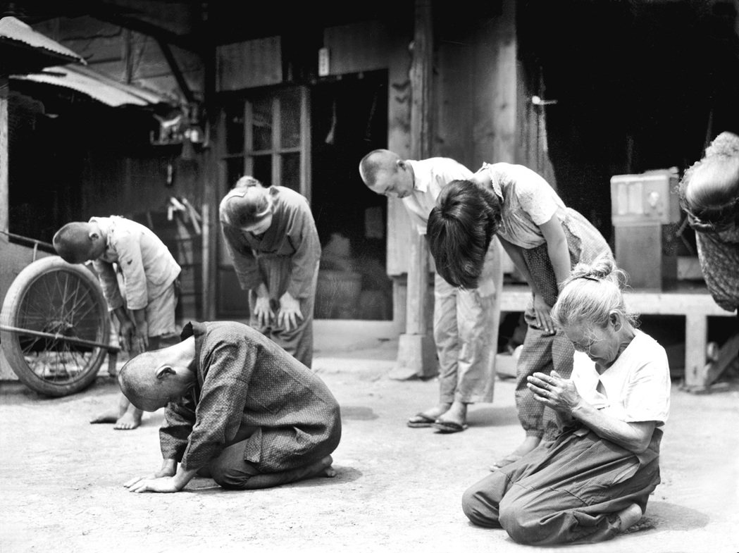 1945年日本敗戰，東京街頭的民眾正在聆聽昭和天皇的「玉音放送」。 圖／美聯社